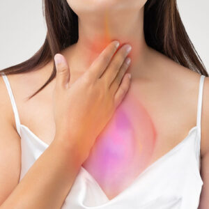 woman holding chest with heartburn