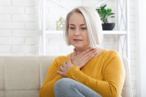 Woman at home with heartburn.